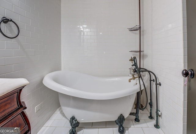 full bathroom with tile walls, a freestanding bath, and tile patterned flooring