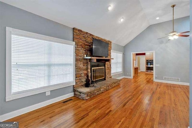 unfurnished living room with baseboards, visible vents, a ceiling fan, and a fireplace