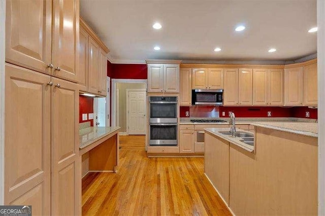 kitchen featuring recessed lighting, a sink, light wood-type flooring, light brown cabinetry, and appliances with stainless steel finishes