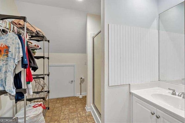 full bathroom with tile patterned floors, vanity, a stall shower, and a walk in closet