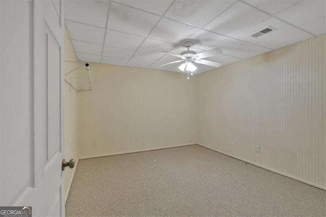 empty room featuring a ceiling fan, visible vents, and a paneled ceiling