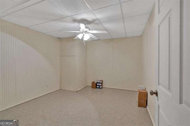 carpeted spare room featuring ceiling fan and a drop ceiling