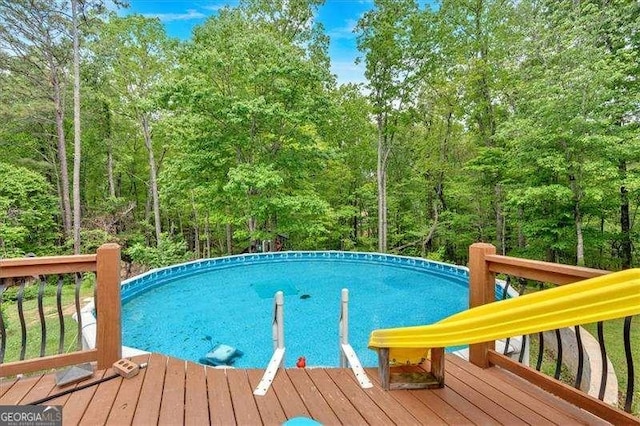 pool featuring a deck and a forest view