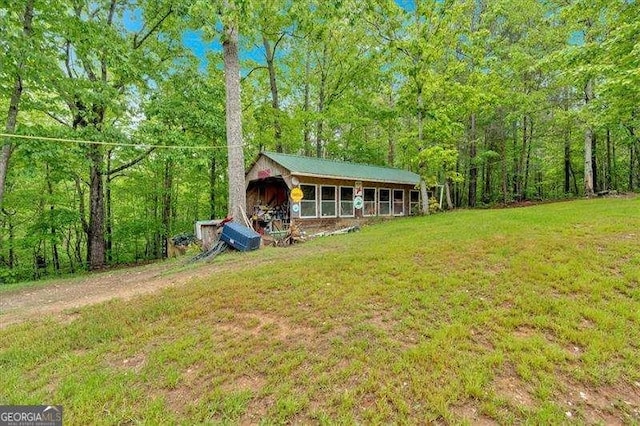 view of outbuilding featuring a view of trees and an outbuilding