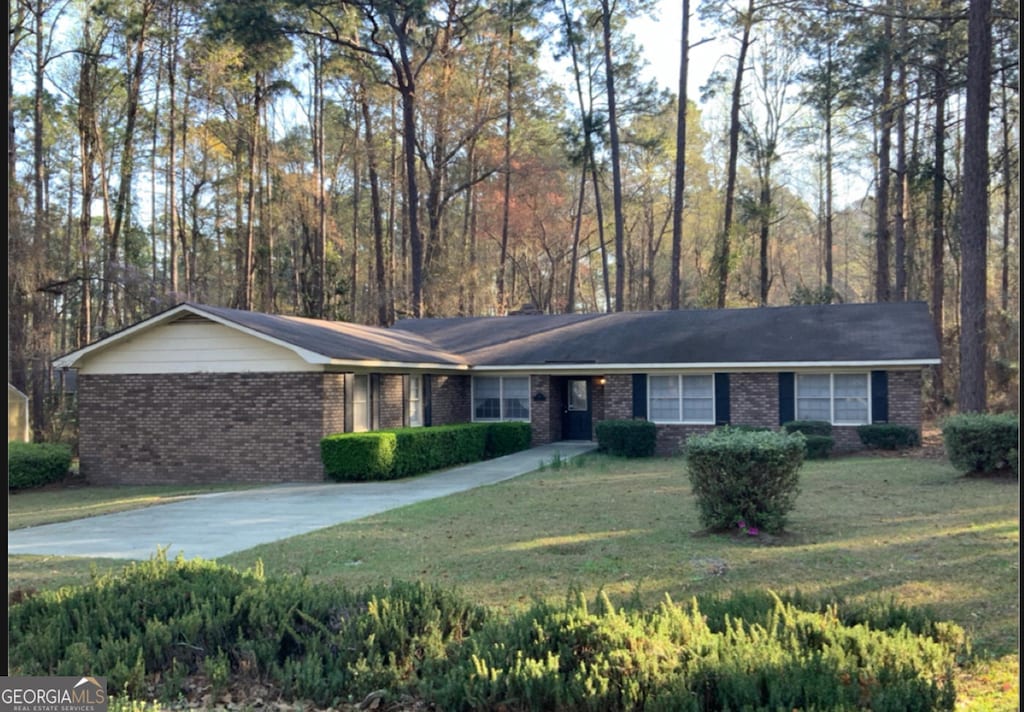 ranch-style house with concrete driveway, a front yard, and brick siding