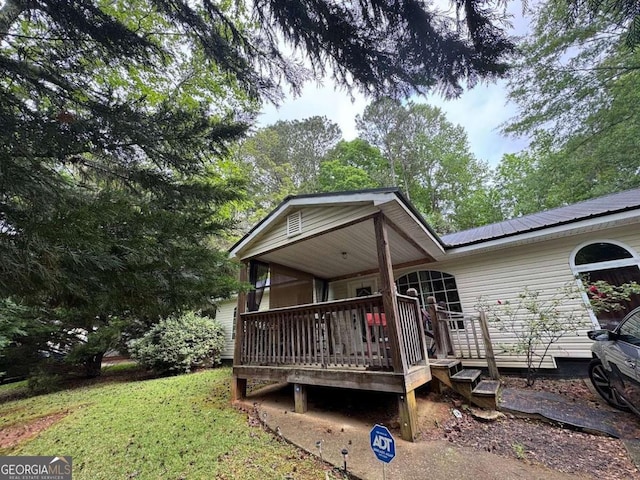 115 Sarsen Cir, Bogart, GA 30622 - view of front of home with a metal roof, a deck, and a front lawn