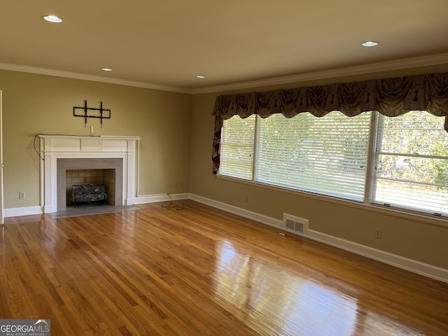 106 Zenith St, Dublin, GA 31021 - unfurnished living room featuring a fireplace with flush hearth, crown molding, visible vents, baseboards, and wood finished floors