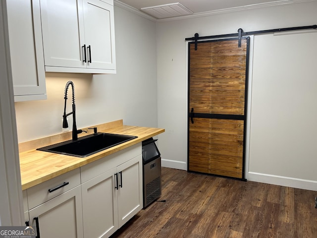 106 Zenith St, Dublin, GA 31021 - kitchen with a sink, dark wood-style flooring, a barn door, baseboards, and butcher block counters