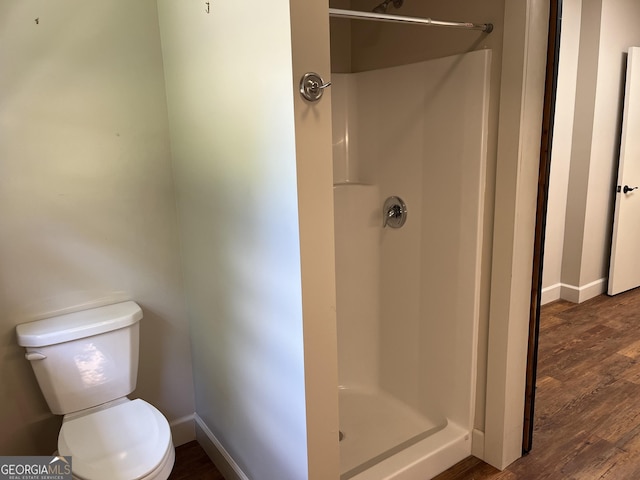 106 Zenith St, Dublin, GA 31021 - bathroom featuring toilet, wood finished floors, a shower stall, and baseboards