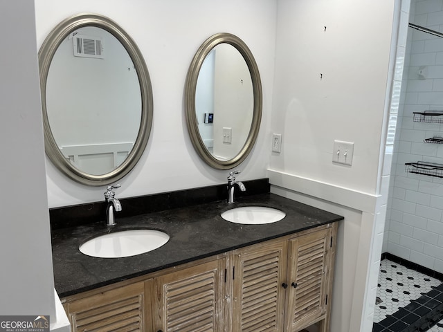 106 Zenith St, Dublin, GA 31021 - full bathroom featuring double vanity, visible vents, a tile shower, and a sink