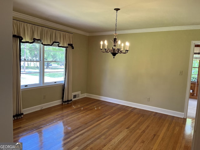 106 Zenith St, Dublin, GA 31021 - empty room with a notable chandelier, visible vents, baseboards, ornamental molding, and wood finished floors
