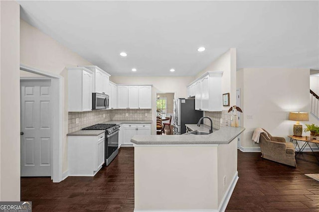 9310 Old Preserve Trl, Ball Ground, GA 30107 - kitchen featuring a sink, decorative backsplash, stainless steel appliances, and a peninsula