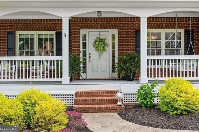 9310 Old Preserve Trl, Ball Ground, GA 30107 - view of exterior entry featuring a porch and brick siding