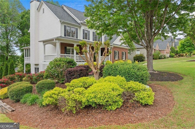 9310 Old Preserve Trl, Ball Ground, GA 30107 - view of front of property with a front yard, a chimney, covered porch, and brick siding