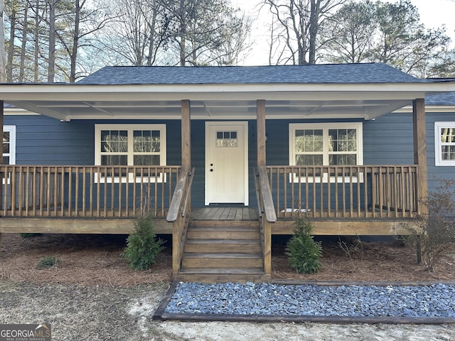 view of front of house with covered porch and roof with shingles