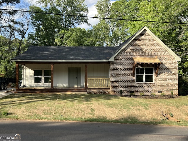 135 Church St, Palmetto, GA 30268 - view of front facade with a porch, a front lawn, crawl space, board and batten siding, and brick siding