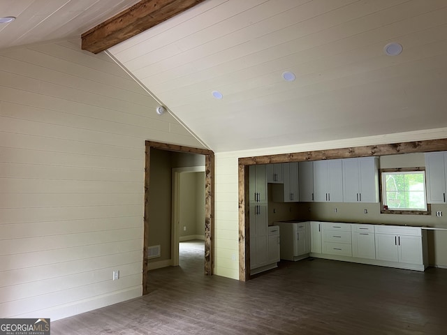 135 Church St, Palmetto, GA 30268 - kitchen featuring wooden walls, visible vents, vaulted ceiling with beams, and dark wood finished floors