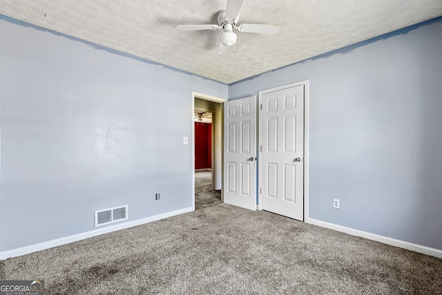 unfurnished bedroom featuring a ceiling fan, visible vents, baseboards, a textured ceiling, and carpet floors