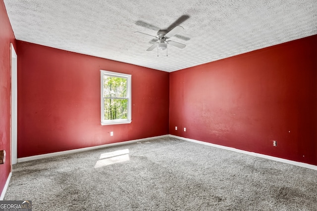 carpeted spare room featuring a textured ceiling, ceiling fan, and baseboards