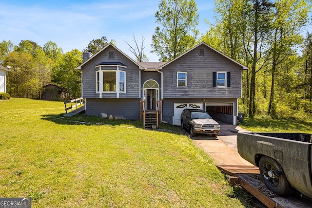 split foyer home featuring a garage, a chimney, driveway, and a front yard