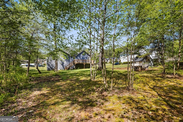 view of yard with a deck and stairs