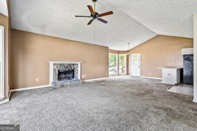 unfurnished living room with carpet flooring, ceiling fan, a textured ceiling, and a fireplace