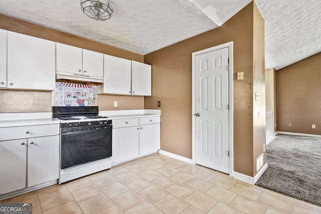 kitchen featuring gas range, a textured ceiling, under cabinet range hood, and light countertops