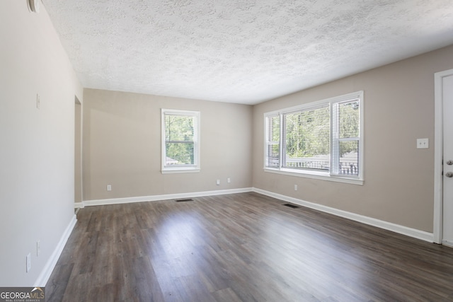 2041 W Flat Shoals Ter, Decatur, GA 30034 - unfurnished living room featuring dark wood-style floors, baseboards, a healthy amount of sunlight, and a textured ceiling
