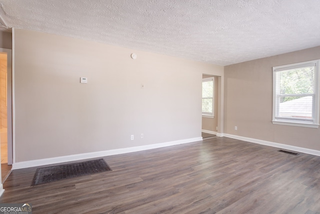 2041 W Flat Shoals Ter, Decatur, GA 30034 - empty room featuring a textured ceiling, a healthy amount of sunlight, and dark wood finished floors