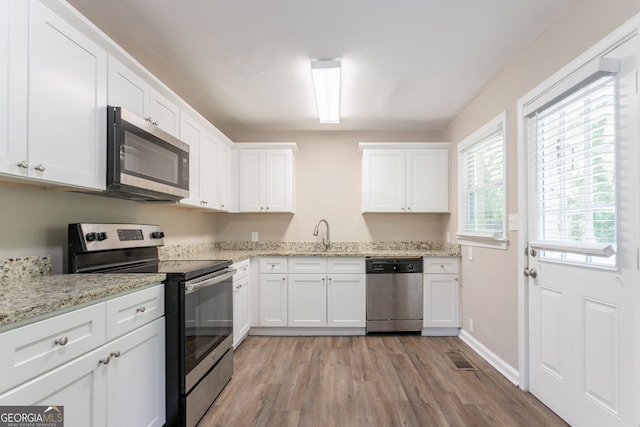 2041 W Flat Shoals Ter, Decatur, GA 30034 - kitchen with light stone countertops, stainless steel appliances, white cabinets, light wood finished floors, and a sink