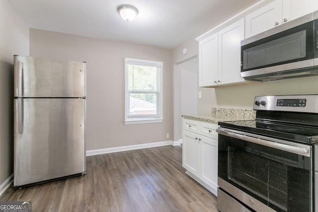 2041 W Flat Shoals Ter, Decatur, GA 30034 - kitchen with wood finished floors, stainless steel appliances, white cabinets, and baseboards