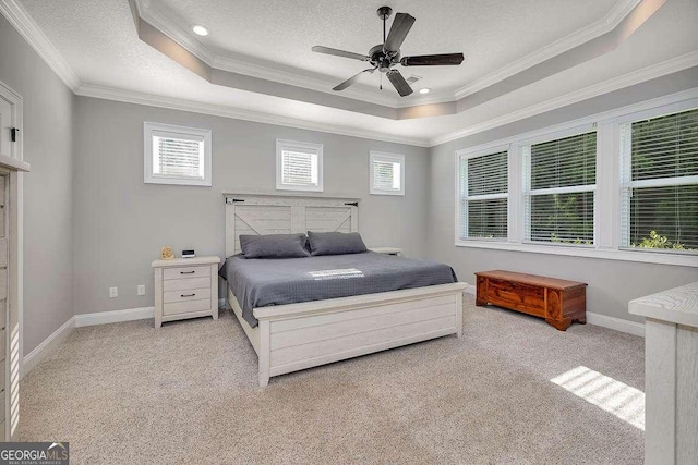 bedroom featuring baseboards, ornamental molding, light carpet, and a raised ceiling