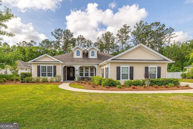 view of front of home featuring a front lawn and a shingled roof