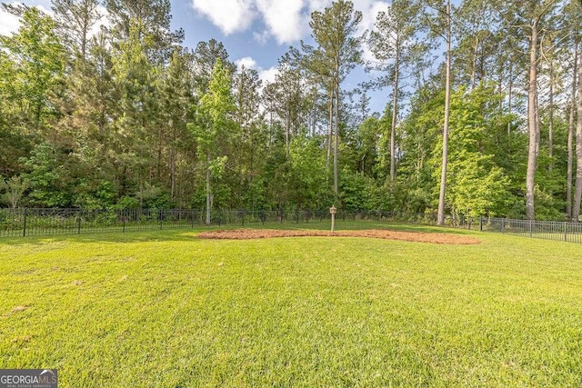 view of yard featuring fence and a forest view