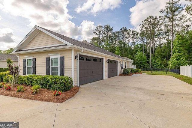 view of side of home featuring fence and driveway