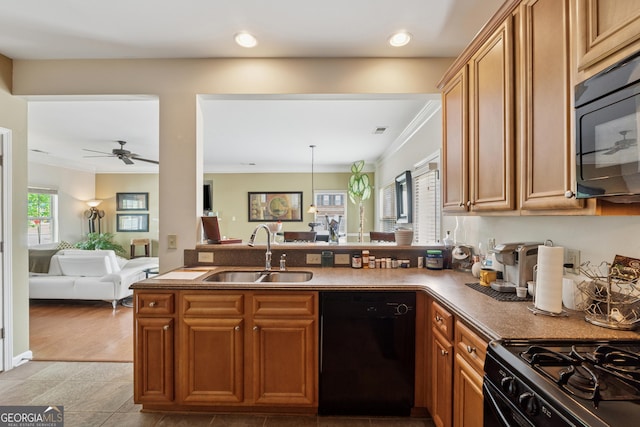 kitchen featuring crown molding, a sink, black appliances, open floor plan, and a peninsula