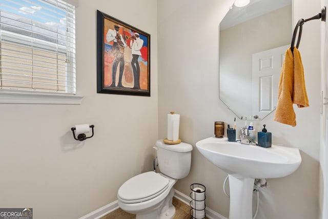 bathroom with toilet and baseboards