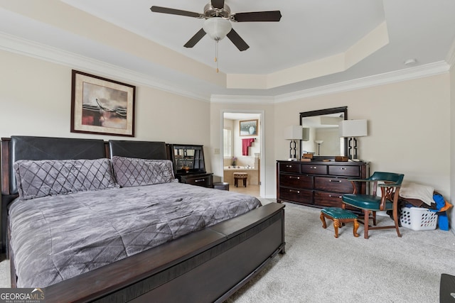 carpeted bedroom featuring a raised ceiling, a ceiling fan, connected bathroom, and ornamental molding