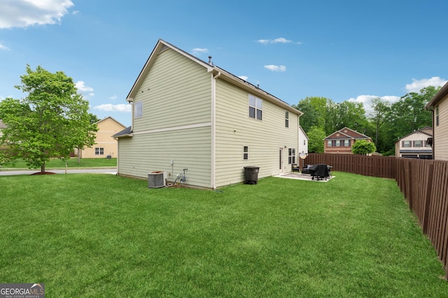 back of house featuring central AC, fence, a patio, and a yard