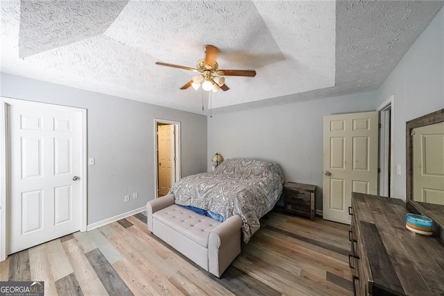 2889 Estuary Dr, Acworth, GA 30101 - bedroom featuring a textured ceiling, baseboards, light wood-style flooring, and a ceiling fan