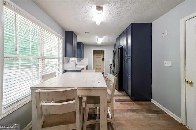 2889 Estuary Dr, Acworth, GA 30101 - kitchen featuring light wood finished floors, a sink, freestanding refrigerator, a textured ceiling, and light countertops