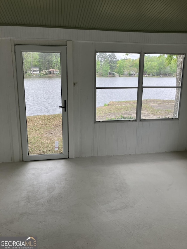 empty room featuring a water view and concrete flooring