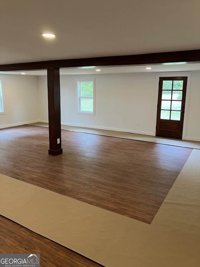 spare room featuring recessed lighting, a wealth of natural light, and dark wood-type flooring