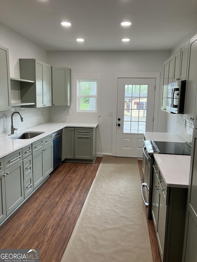 kitchen featuring a sink, dark wood finished floors, stainless steel appliances, recessed lighting, and tasteful backsplash