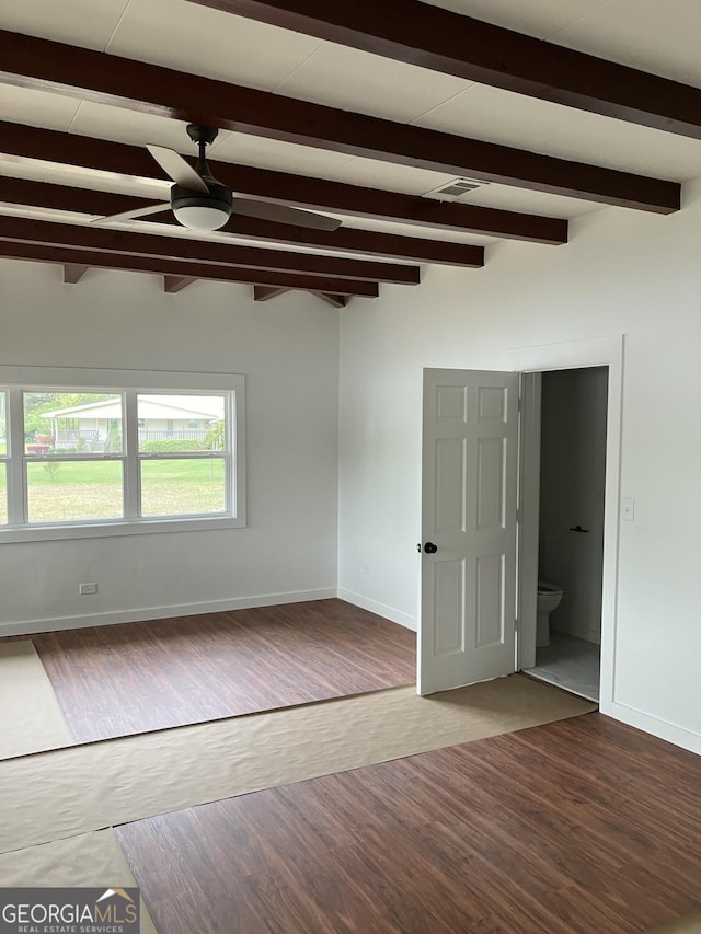empty room featuring baseboards, a ceiling fan, wood finished floors, and beamed ceiling