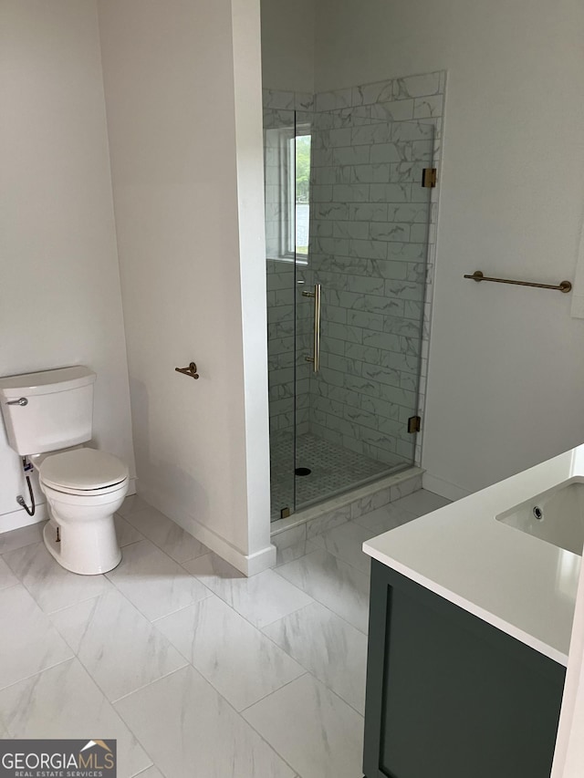 full bath with a stall shower, vanity, baseboards, toilet, and marble finish floor