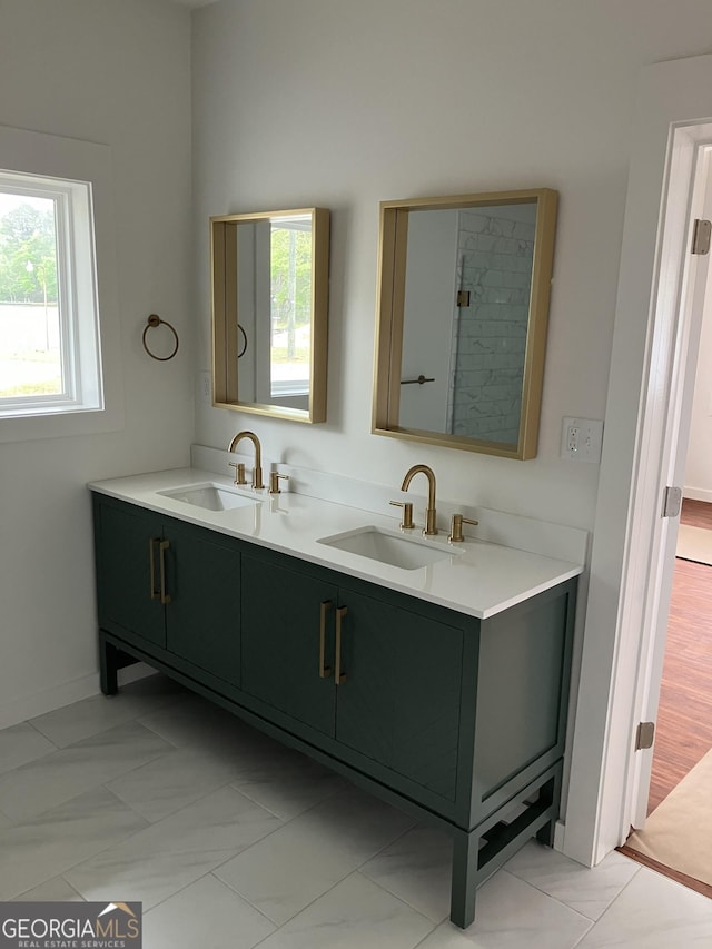 bathroom featuring double vanity, baseboards, and a sink