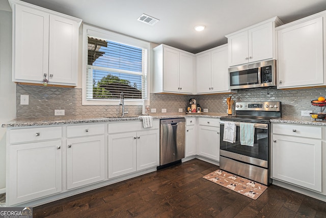 3399 In Bloom Way, Auburn, GA 30011 - kitchen with appliances with stainless steel finishes, a sink, white cabinetry, tasteful backsplash, and light stone countertops