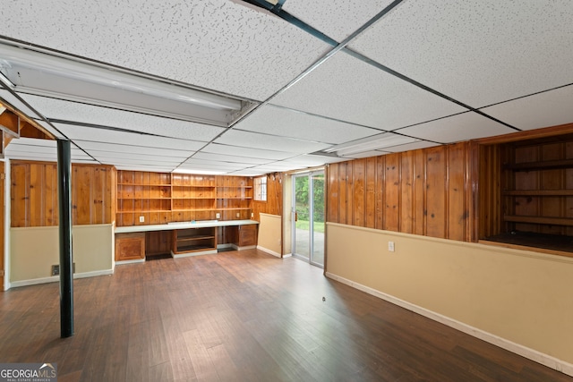 2823 Connally Dr SW, Atlanta, GA 30311 - unfurnished living room with built in features, wooden walls, baseboards, wood finished floors, and a drop ceiling
