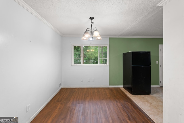 2823 Connally Dr SW, Atlanta, GA 30311 - unfurnished dining area featuring wood finished floors, a chandelier, crown molding, a textured ceiling, and baseboards